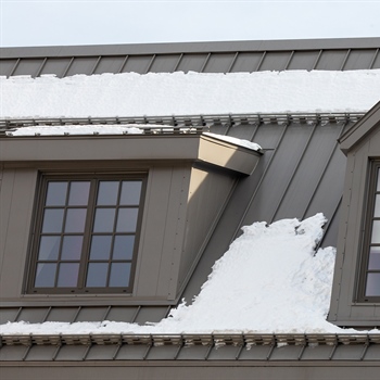 Pre-assembled AceClamp metal roof snow bars safeguarding Delmar Hotel and its guests from snow hazards.