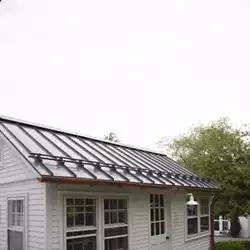 Close-up of powder-coated metal roof snow stops ready to prevent the snow avalanche.